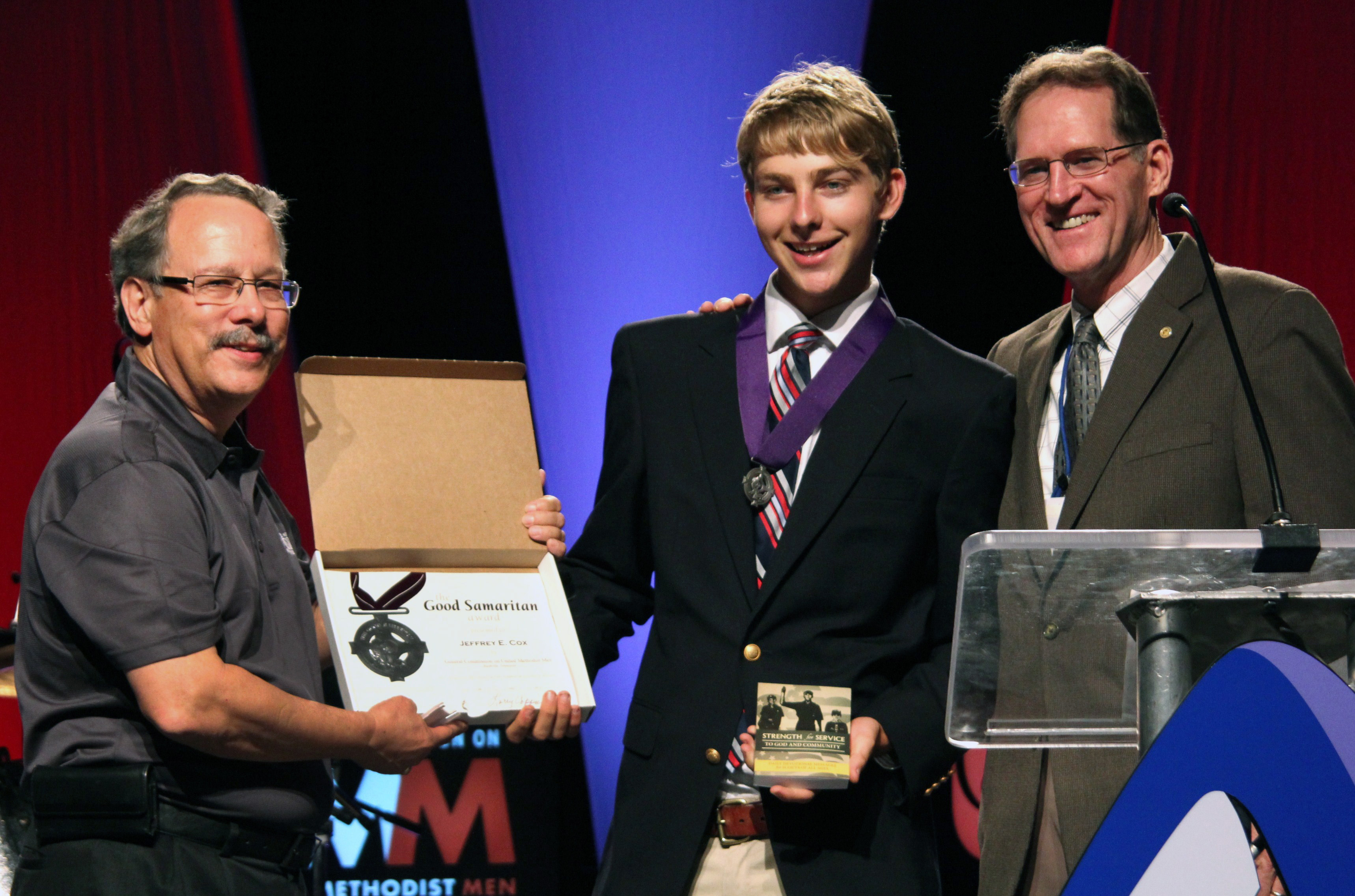 Jeff Cox (center) receives the Good Samaritan Award for his 9/11 Eagle Scout Project. To the left is Gil C. Hanke, top staff executive with United Methodist Men and Larry Coppock, director and contributing editor of Strength for Service, Inc. The Award ceremony was held during the July 12-14, 2013 United Methodist Men's 11th national gathering held in Nashville, Tenn. at Belmont University. Photo by Bob Vogt.